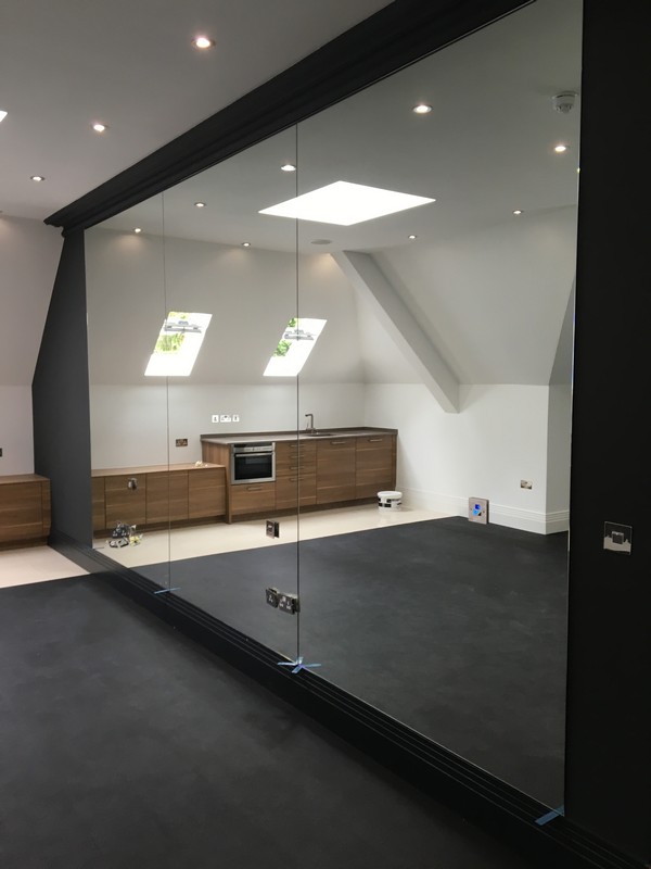 Frameless glass partition in loft conversion by High Wycombe glaziers